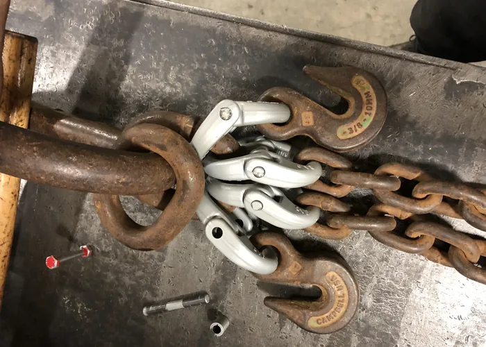 A chain sling being rebuilt with new self-locking hooks