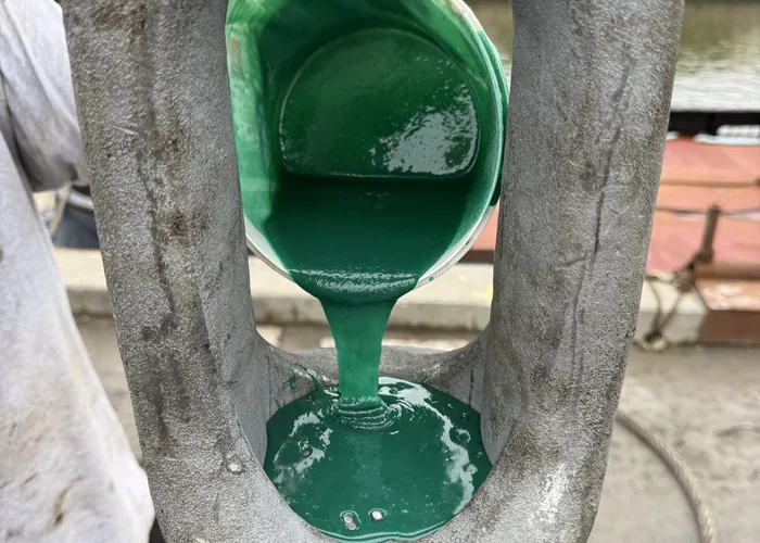Green resin being poured into an open spelter socket on the dock