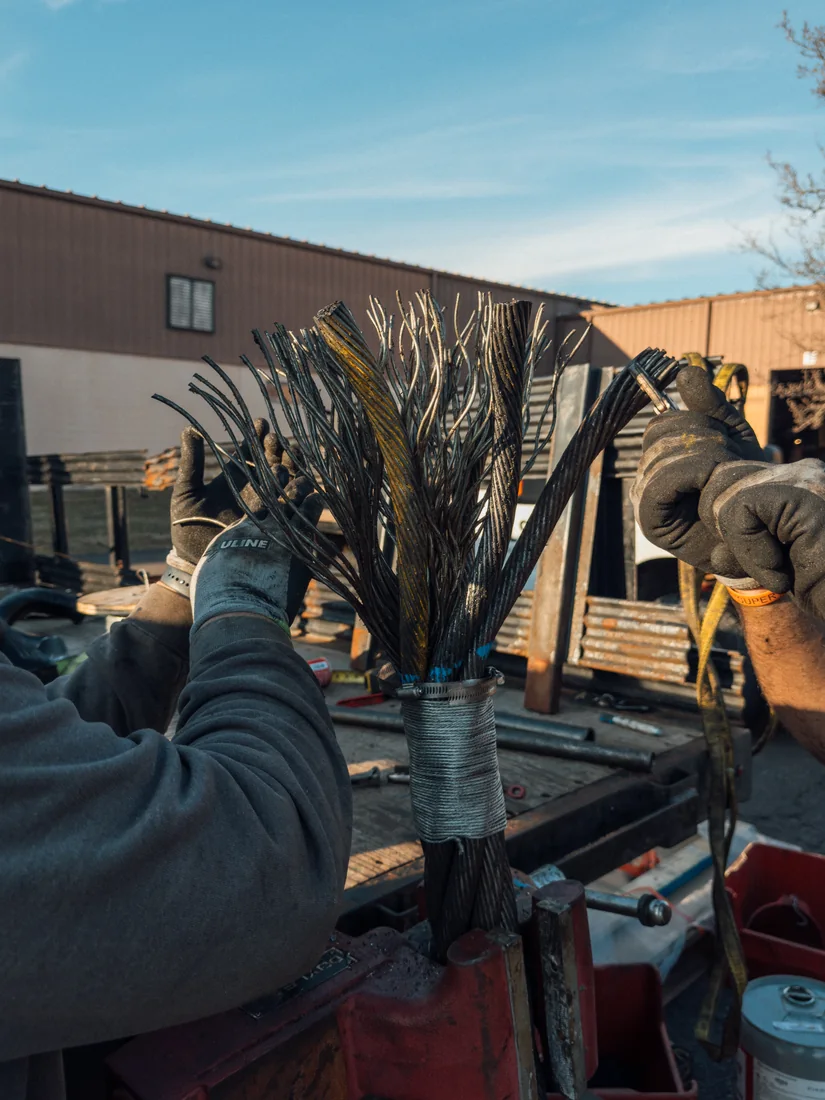 A wire rope end opened into a broom, every wire separated above the seizing, ready for cleaning and pouring