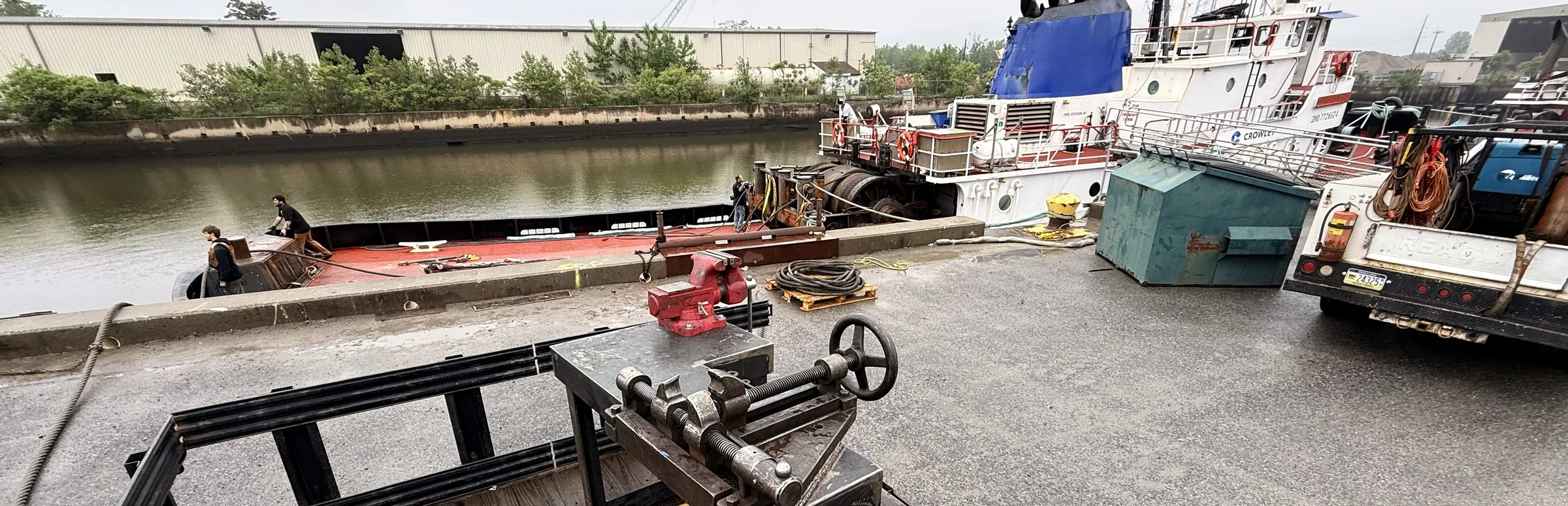 The Nelson socket pouring rig set up on a dock, with a tug and a barge tied up behind it and the service truck alongside