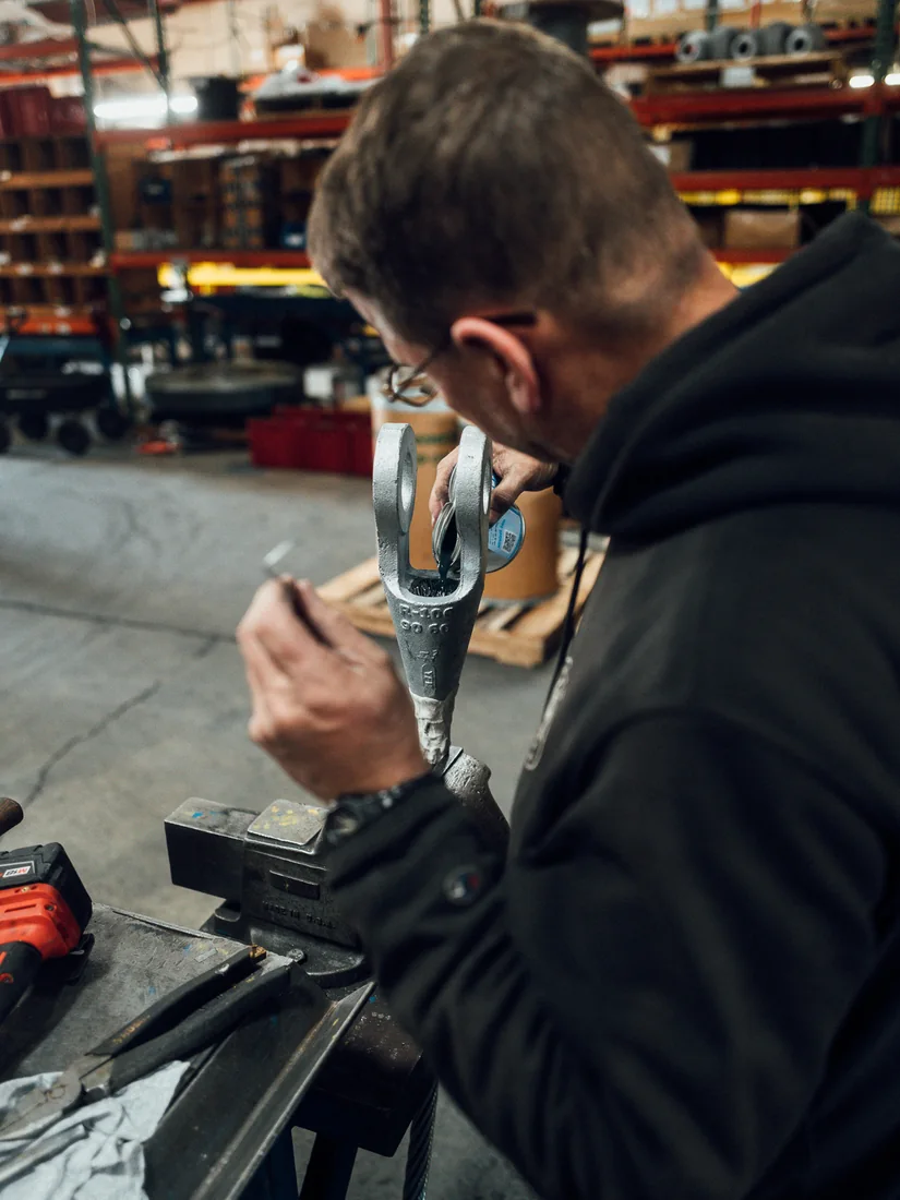 A technician pouring resin into a socket held upright in a bench vise in the Hatfield shop